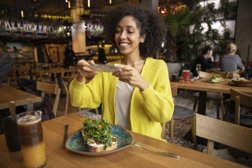 Mujer echando foto a la comida en restaurante